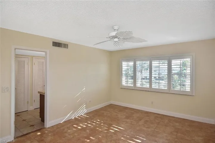 Tiled spare room featuring a ceiling fan and a textured ceiling