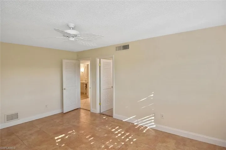 Unfurnished bedroom with a closet, a textured ceiling, and ceiling fan