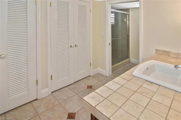 Full bath with a closet, a bath, and a shower stall