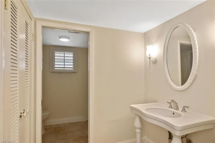 Bathroom with a closet and light tile patterned flooring