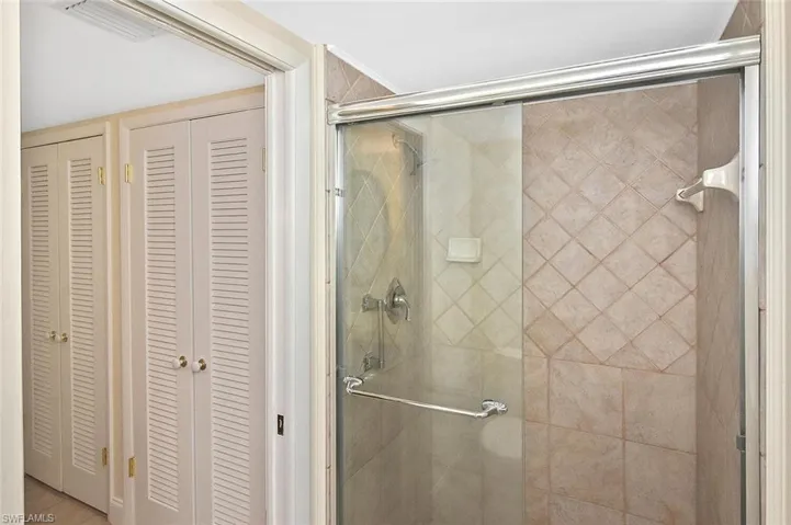 Bathroom featuring a closet and a stall shower