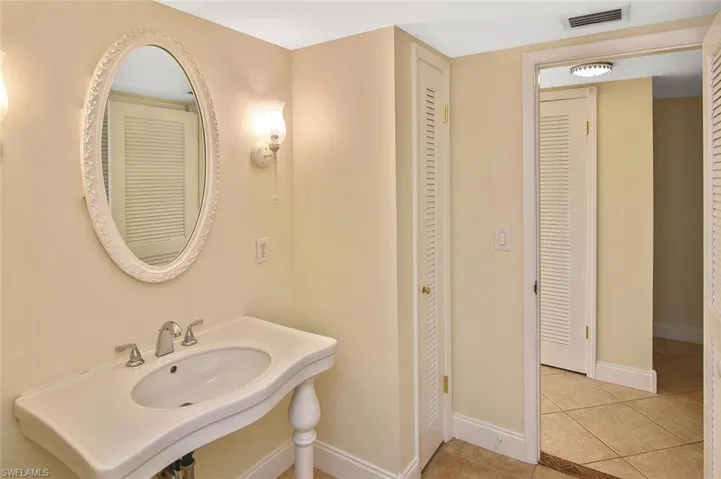 Bathroom with a closet and light tile patterned floors