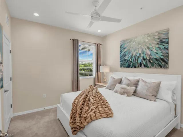 Carpeted bedroom featuring ceiling fan