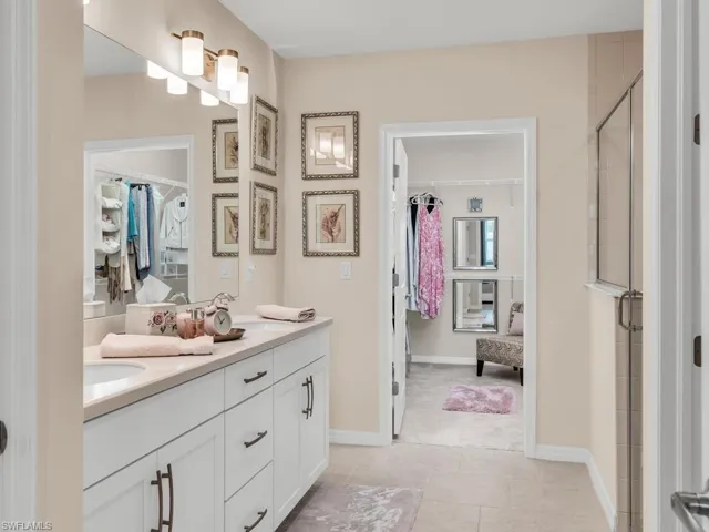 Bathroom with tile patterned floors, walk in shower, and vanity