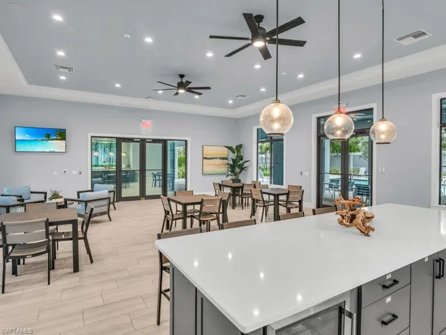 Kitchen featuring light wood-type flooring, ceiling fan, hanging light fixtures, and french doors