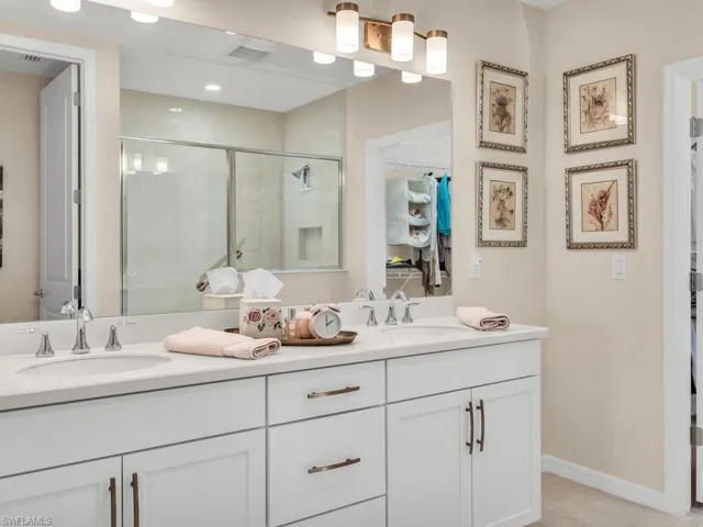 Bathroom with tile patterned flooring, an enclosed shower, and vanity