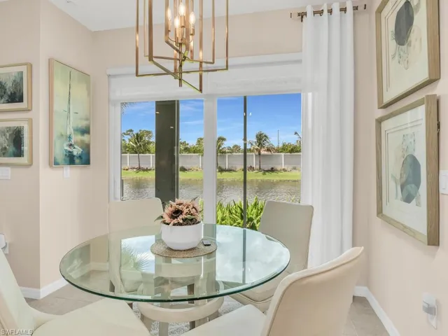 Dining area featuring a water view, light tile patterned floors, and an inviting chandelier