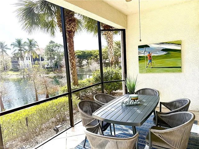 Sunroom featuring outdoor dining space and a water view
