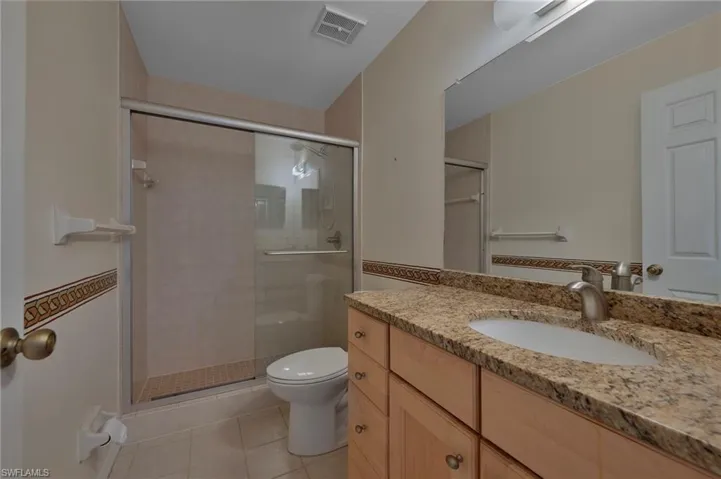 Primary Bath with Wood Cabinets, Granite Countertops, Glass Doors, Tile Floors
