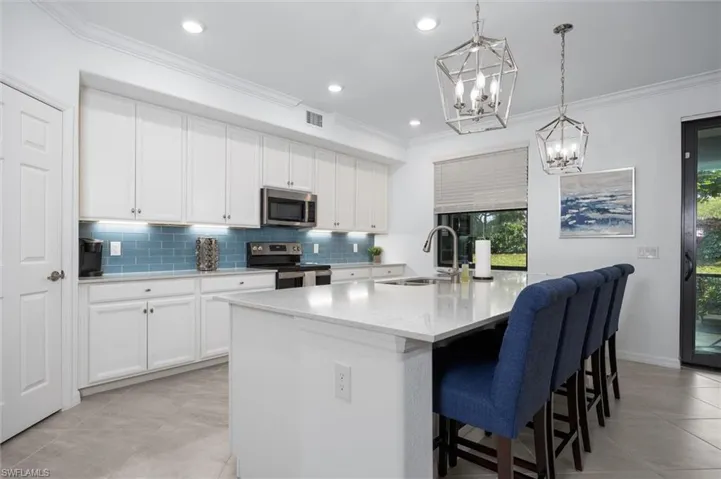 Large island, stainless appliances, walk in pantry - under cabinet lighting and tile back splash