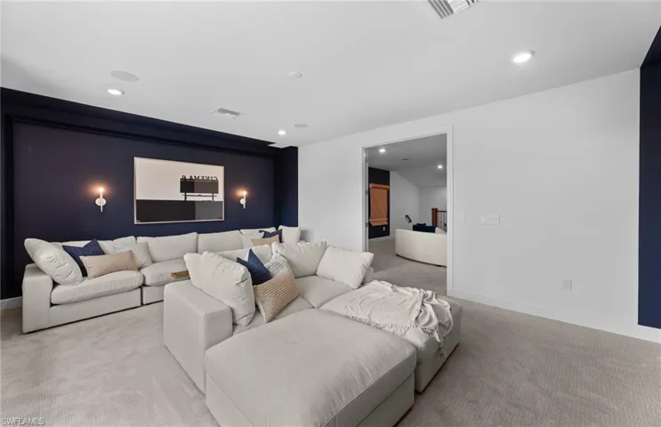 Home theater room with light carpet and recessed lighting