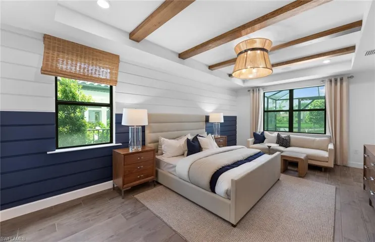 Bedroom featuring light wood-type flooring, recessed lighting, beam ceiling, and a raised ceiling