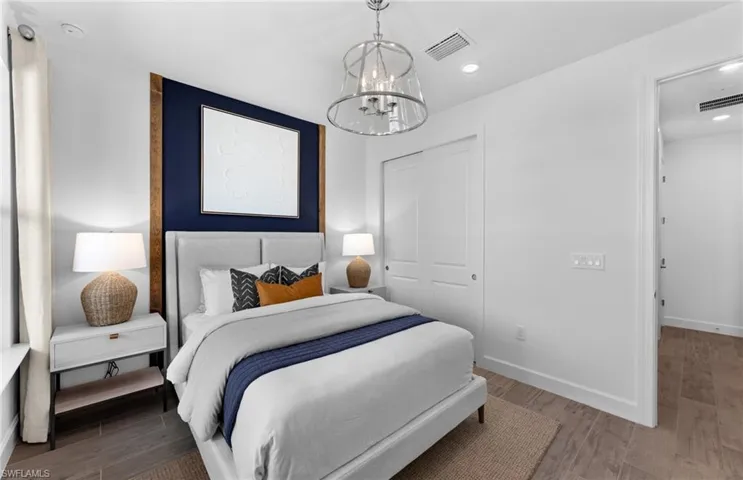 Bedroom with a chandelier, wood finished floors, and a closet
