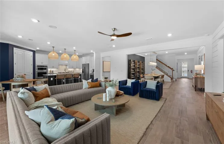 Living room with ceiling fan, light wood-style flooring, and recessed lighting