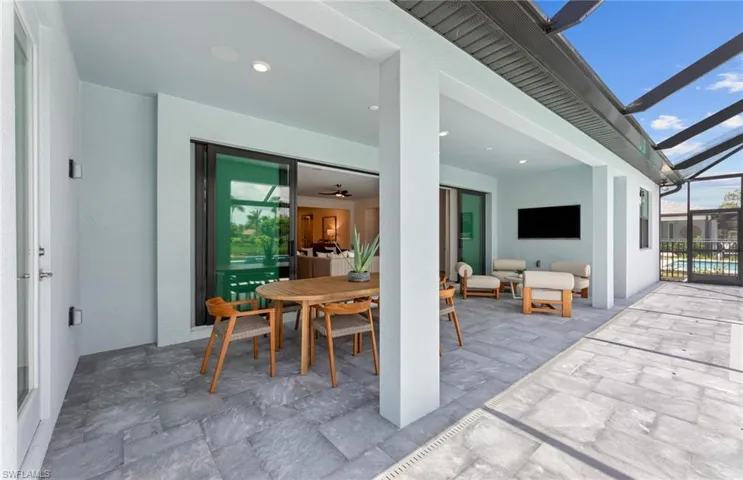 View of patio with a sunroom, a lanai, and outdoor dining area