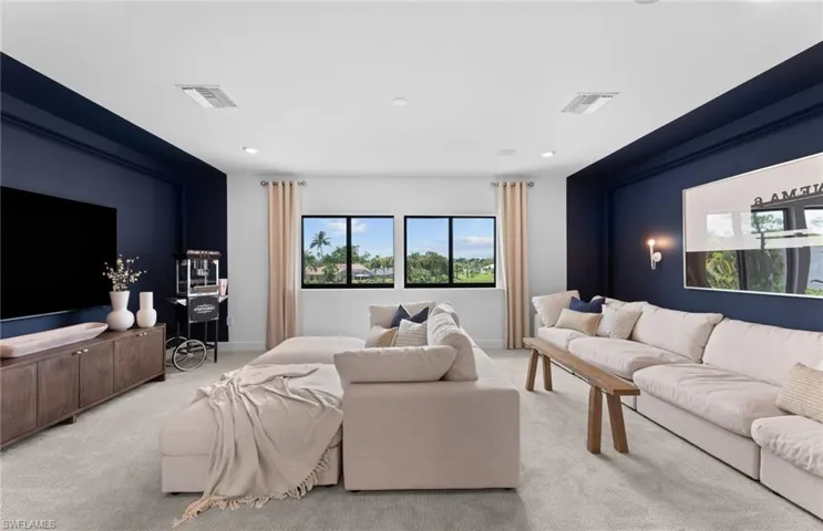 Living area with light colored carpet and recessed lighting