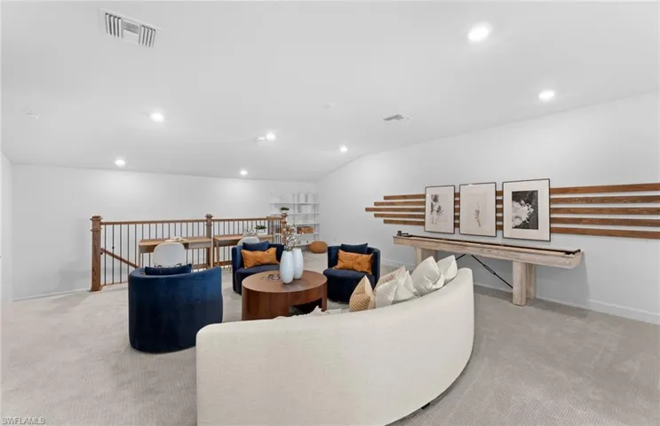 Living area with light carpet, recessed lighting, and vaulted ceiling