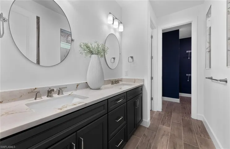 Bathroom with double vanity and wood finish floors