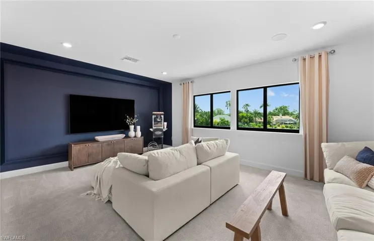 Living area featuring light colored carpet and recessed lighting