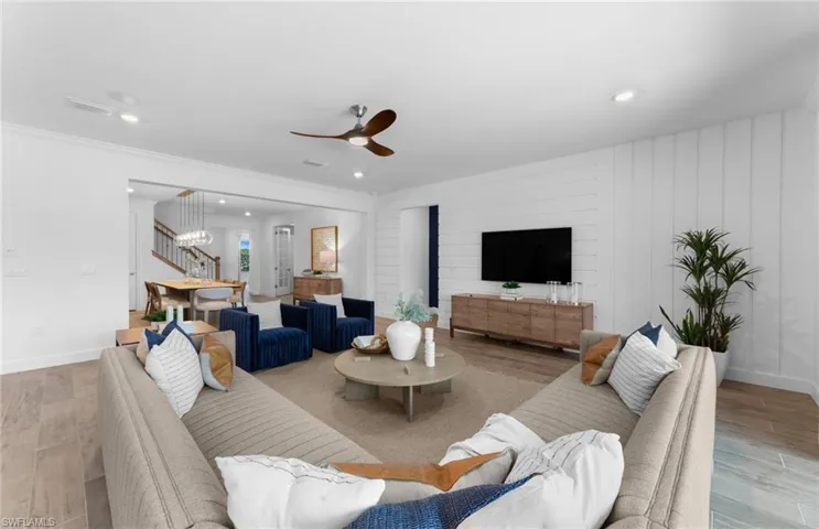 Living area featuring wood finished floors, a ceiling fan, recessed lighting, and crown molding
