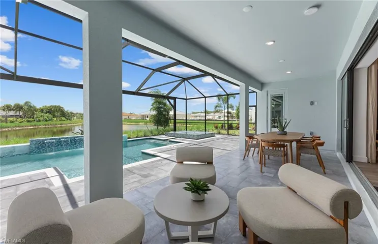 Swimming pool featuring a sunroom, a patio, a lanai, outdoor dining area, and a water view