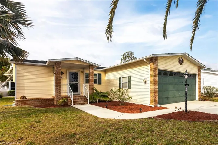 View of front of home featuring a front lawn, driveway, and an attached garage