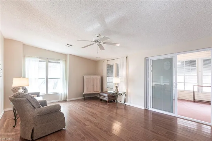 Sitting room with wood finished floors, baseboards, ceiling fan, and visible vents