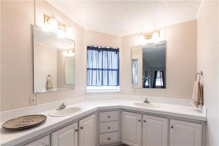 Bathroom featuring double vanity, a sink, and a textured ceiling