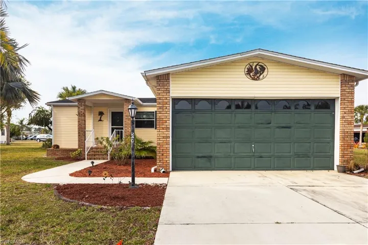 Single story home featuring a front yard, concrete driveway, and an attached garage