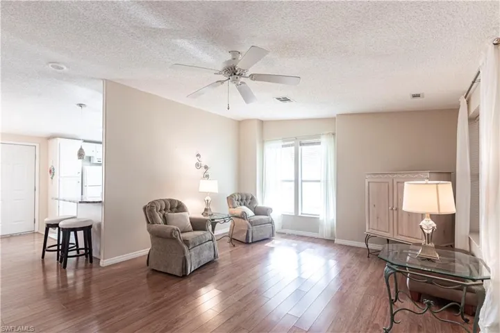 Sitting room featuring baseboards, visible vents, a ceiling fan, and wood finished floors