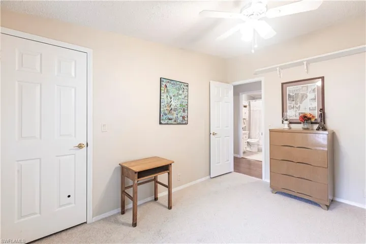 Bedroom with light carpet, baseboards, ceiling fan, and a textured ceiling
