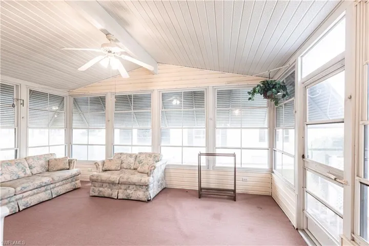 Sunroom / solarium with a ceiling fan, plenty of natural light, and carpet