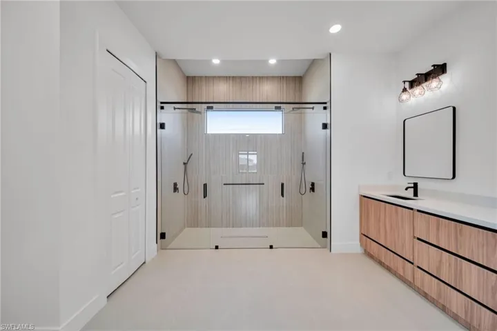 Full bathroom with vanity, a shower stall, and recessed lighting