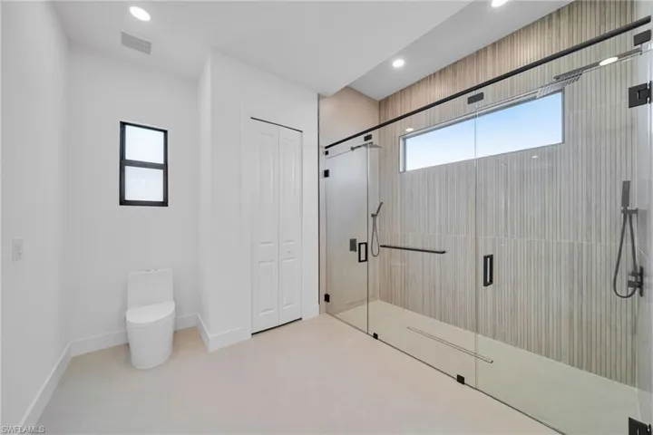 Bathroom with a closet, a stall shower, and recessed lighting