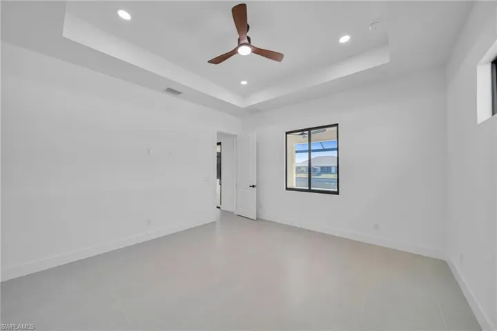 Spare room featuring a ceiling fan, recessed lighting, and a raised ceiling