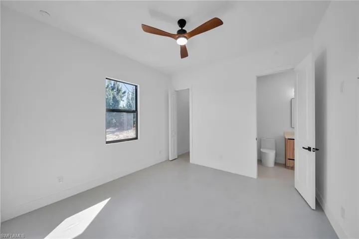 Unfurnished bedroom featuring a ceiling fan and finished concrete flooring