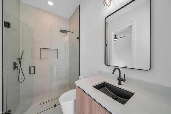 Bathroom featuring vanity, walk in shower, and recessed lighting
