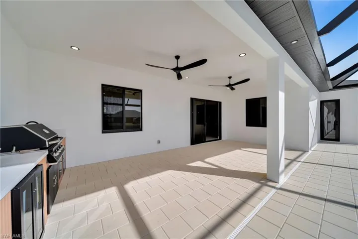 View of patio / terrace with ceiling fan, area for grilling, and glass enclosure