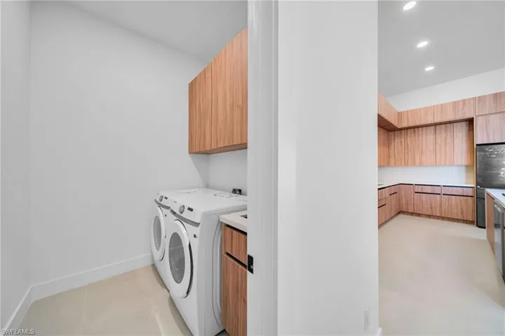 Laundry room featuring independent washer and dryer, cabinet space, light tile patterned flooring, and recessed lighting
