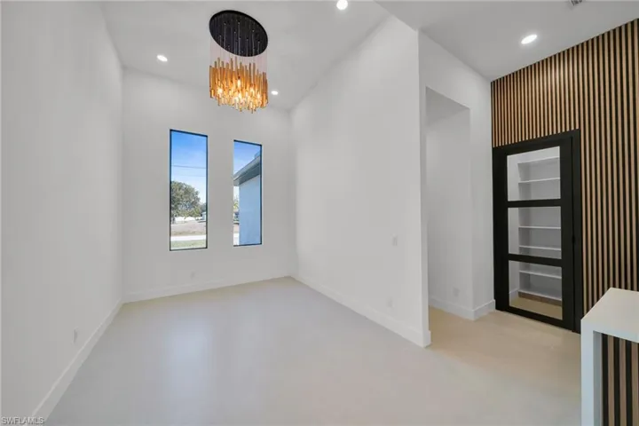 Empty room with baseboards and hanging lights