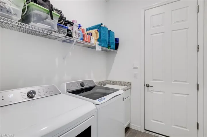 Washroom featuring cabinets, sink, light wood-type flooring, and washer and dryer