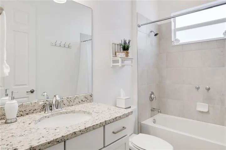 Full bathroom featuring vanity, toilet, and shower / tub combo with curtain