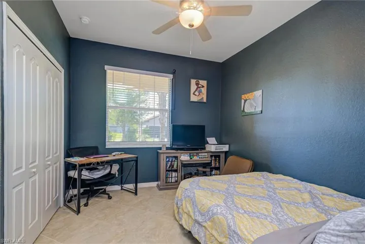 Room featuring a window with horizontal blinds, ceiling fan with integrated lighting, and tile flooring