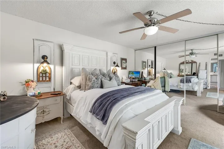 Carpeted bedroom featuring ceiling fan, a closet, and a textured ceiling