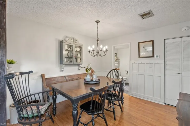 Dining area featuring a chandelier, a textured ceiling, and light hardwood / wood-style flooring
