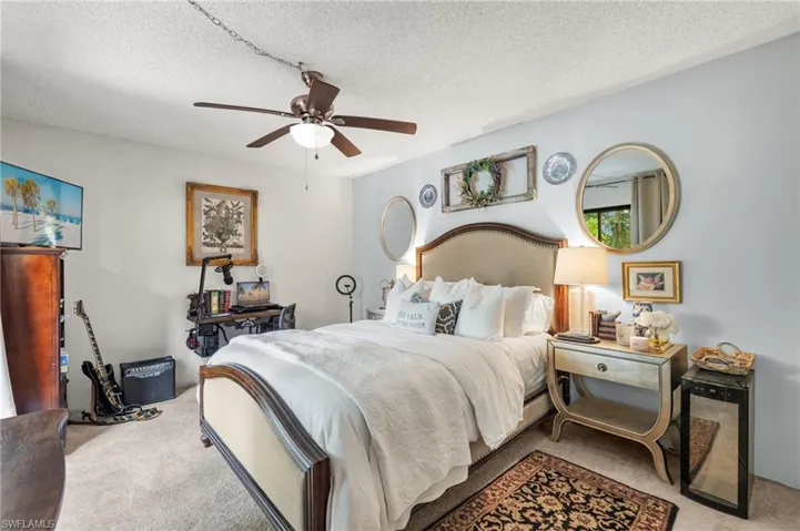 Bedroom featuring carpet, ceiling fan, and a textured ceiling