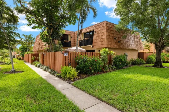 View of property exterior featuring a yard and a balcony
