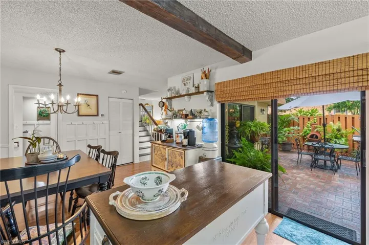 Dining space with beam ceiling, a notable chandelier, and a textured ceiling