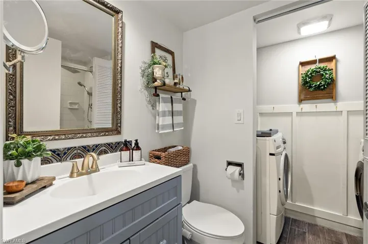 Bathroom featuring oversized vanity, washer / clothes dryer, toilet, and wood-type flooring
