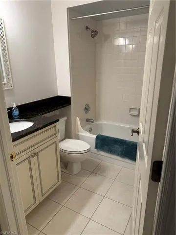 Bathroom featuring vanity, shower / bathtub combination, and light tile patterned floors